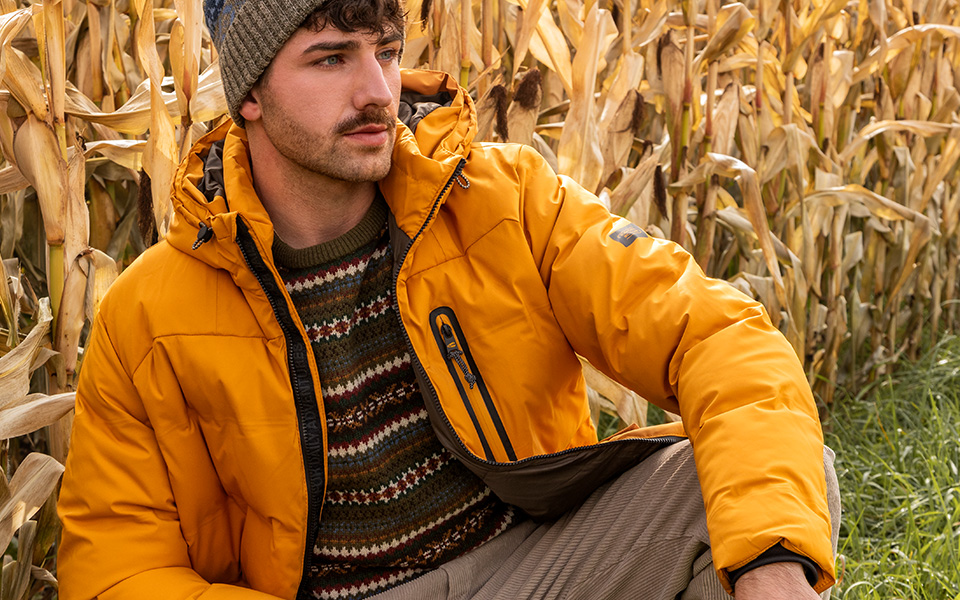 Gelbe Daunenjacke und gemusterter Pullover, im Freien getragen