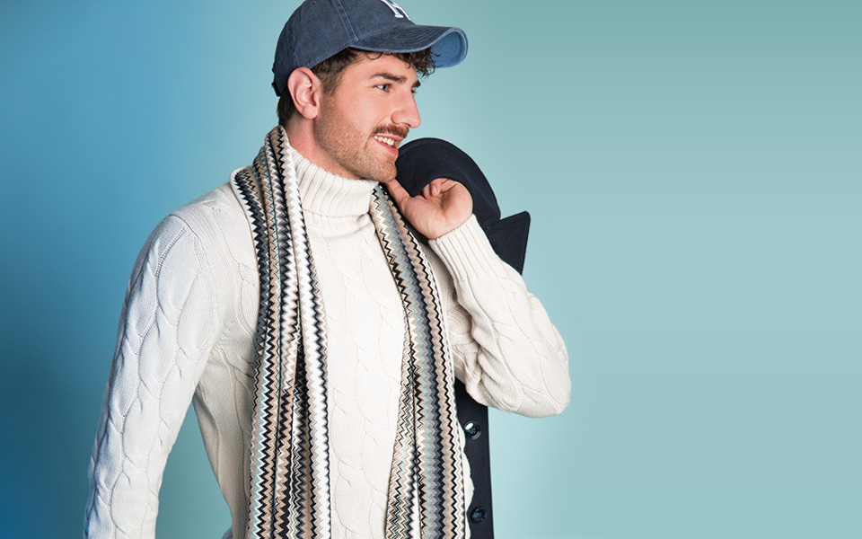 Hochwertiger Zopfstrick-Pullover in Weiß mit gemustertem Schal, lässig kombiniert mit einer Cap