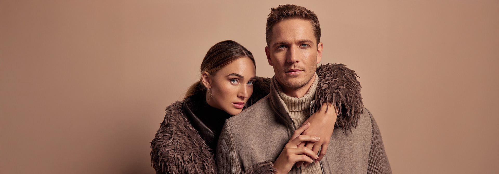 Mann in grauem Wollmantel mit Strickkragen, elegant präsentiert