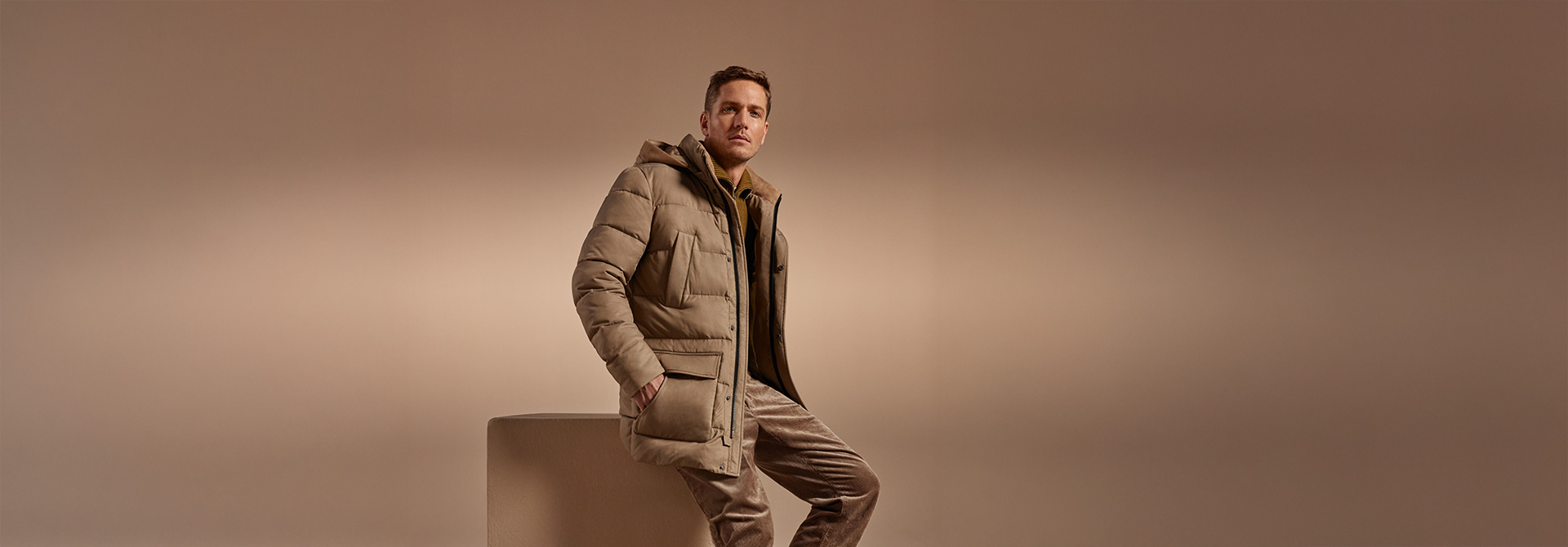 Herren Daunenjacke in Beige, getragen mit Kapuze und Taschen, elegant präsentiert