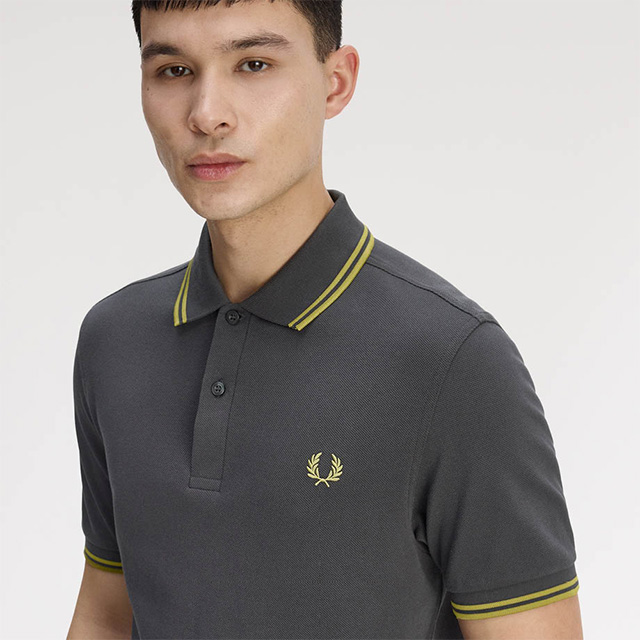 Graues Poloshirt mit gelben Streifen, aus Baumwolle, klassisch geschnitten, von Mann getragen