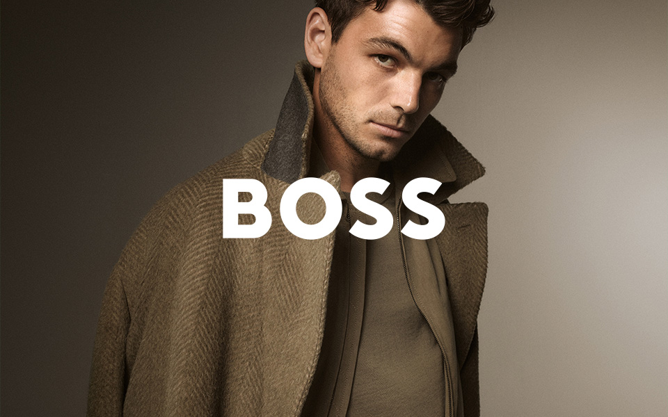 Mann in olivgrünem Mantel und Pullover aus Wolle, lässig präsentiert