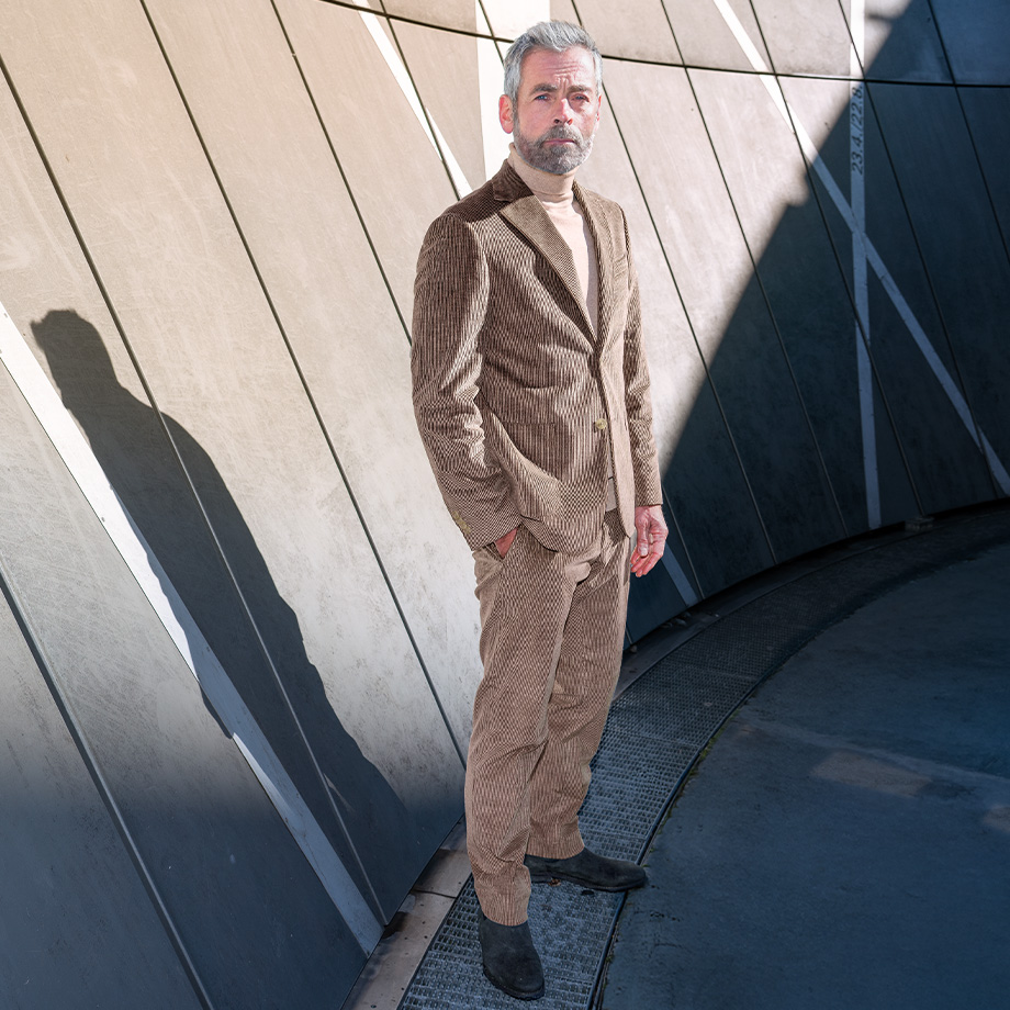 Herr in braunem Cordanzug mit Rollkragenpullover, lässig im Freien