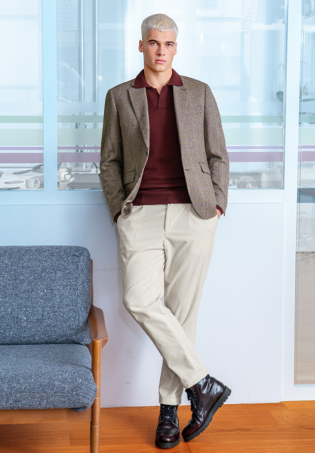 Herr im beigen Sakko mit burgunderfarbenem Pullover, cremefarbene Hose, lässig-legerer Look