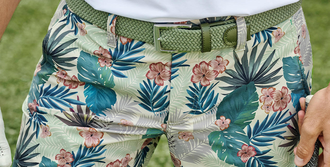 Nahaufnahme einer floral gemusterten Shorts in verschiedenen Grüntönen, kombiniert mit einem farblich abgestimmten Gürtel.