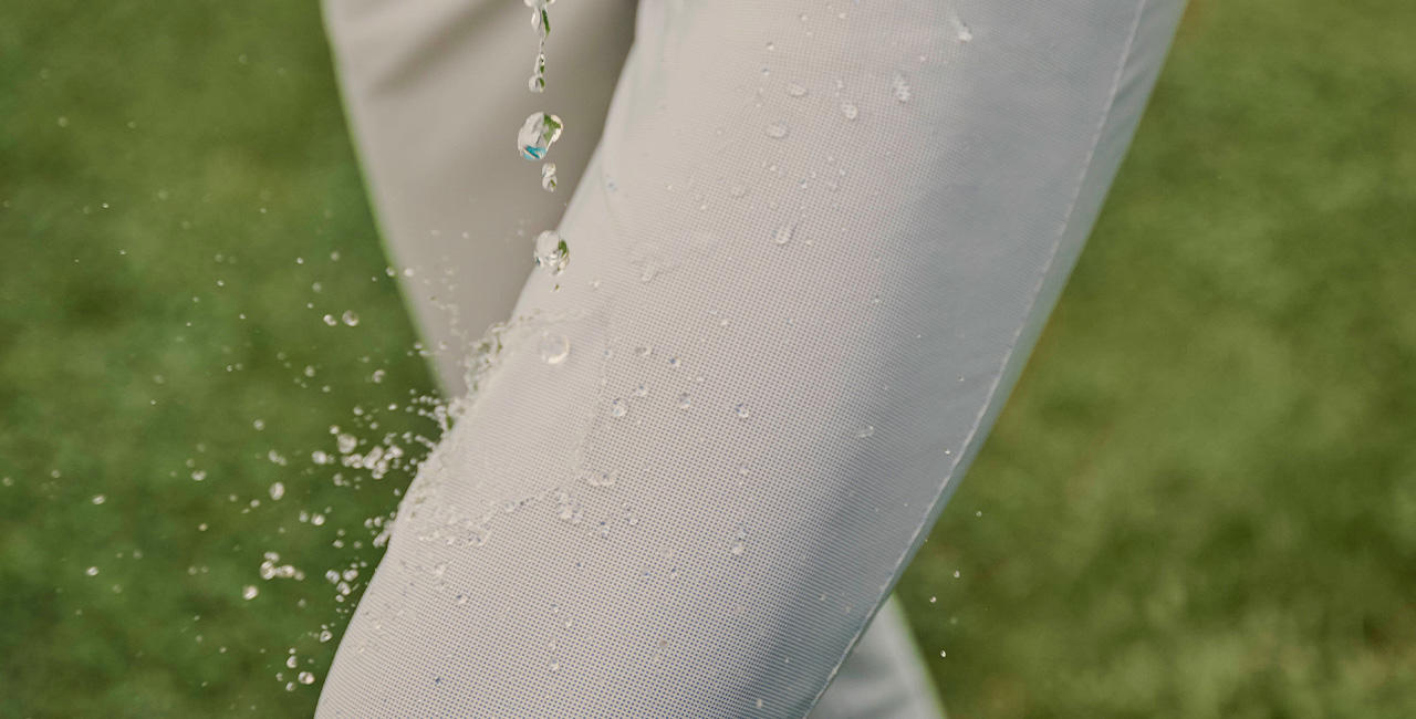 Nahaufnahme einer Damenhose in beige von der Wassertropfen abperlen.