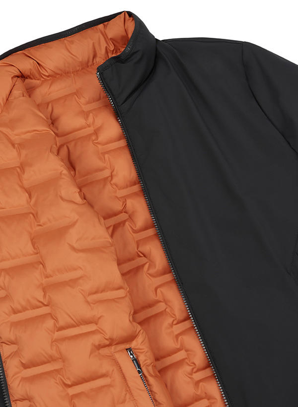 Eine Nahaufnahme einer schwarzen Jacke mit orange gesteppten Innenfutter