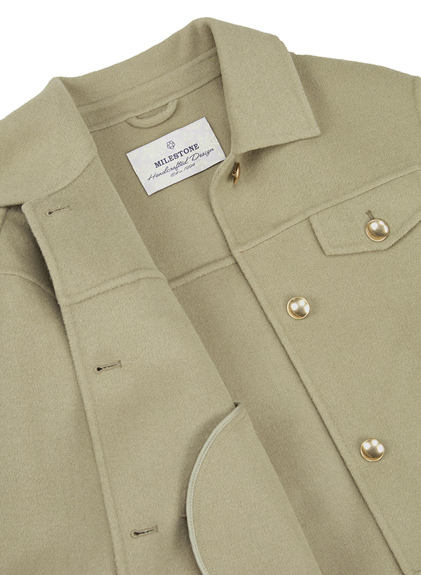 Eine Nahaufnahme einer olivgrünen Wolljacke