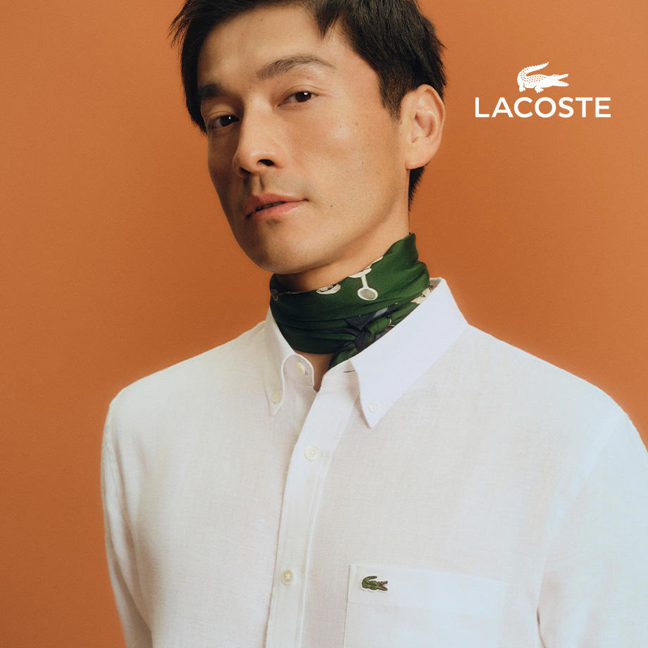 Porträt eines Mannes mit weißem Hemd und grünem Halstuch – klassisch-eleganter Stil von LACOSTE.