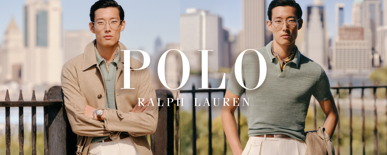 Ein Mann trägt einen beigen Sommertrenchcoat über einem mintgrünen Poloshirt und eine hellbeige Hose. Er lehnt an einem Geländer mit Skyline im Hintergrund. Oben rechts ist das Polo Ralph Lauren Logo eingeblendet.
