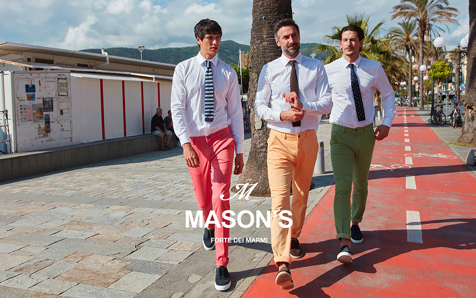Drei junge Männer in farbenfrohen Chinos laufen durch eine Fußgängerzone. In der Mitte ist das Logo: Mason's