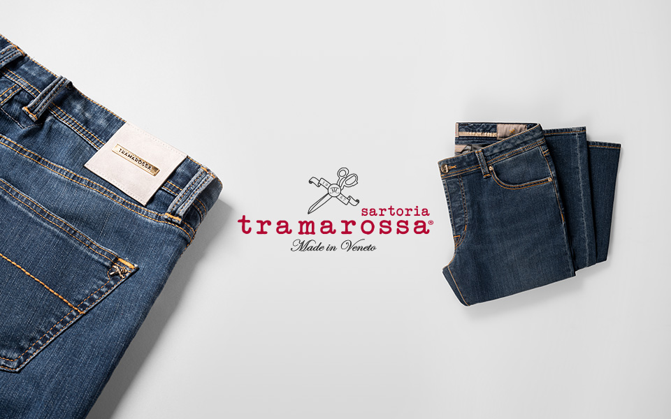 Zwei gefaltete Jeans auf neutralem Hintergrund. In der Mitte ist das Logo: sartoria tramarossa