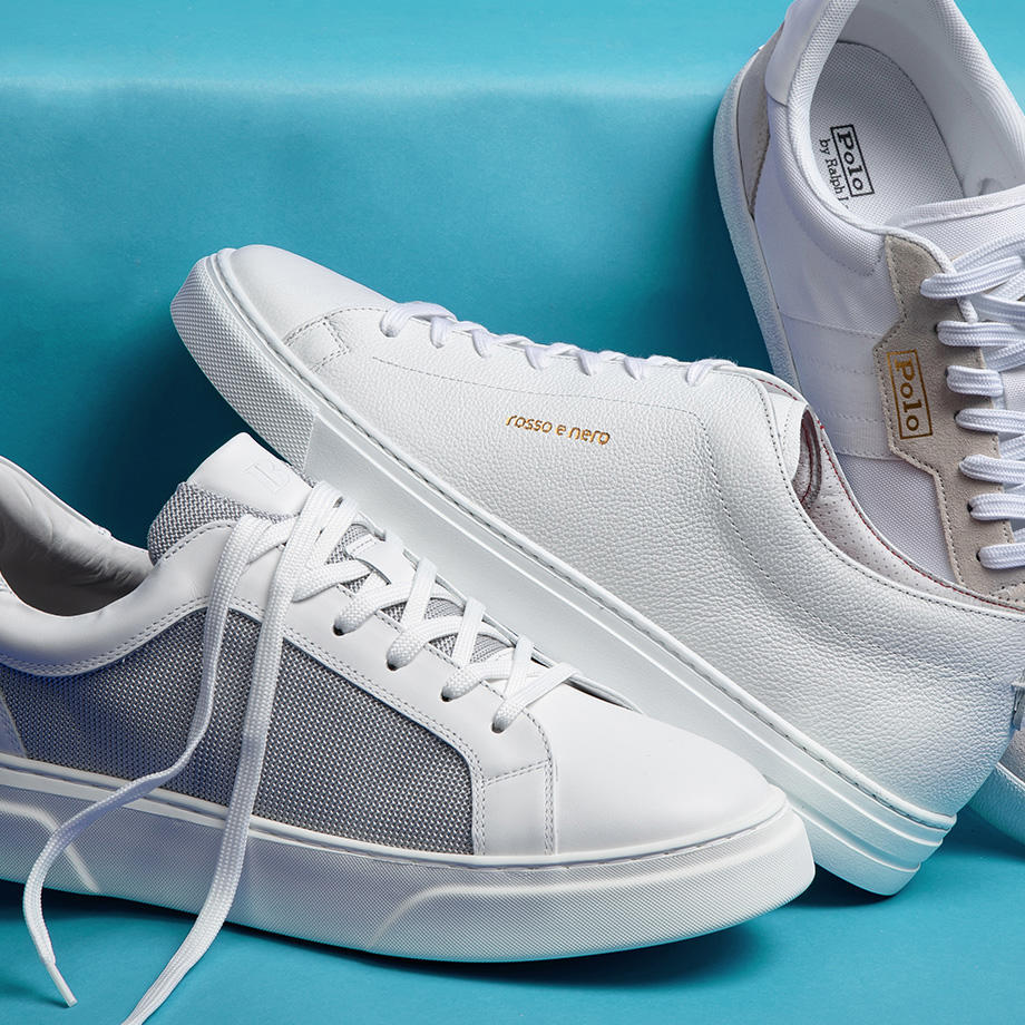 Weiße Sneaker mit Mesh-Einsätzen auf blauem Hintergrund, sportlich und modern gestylt.