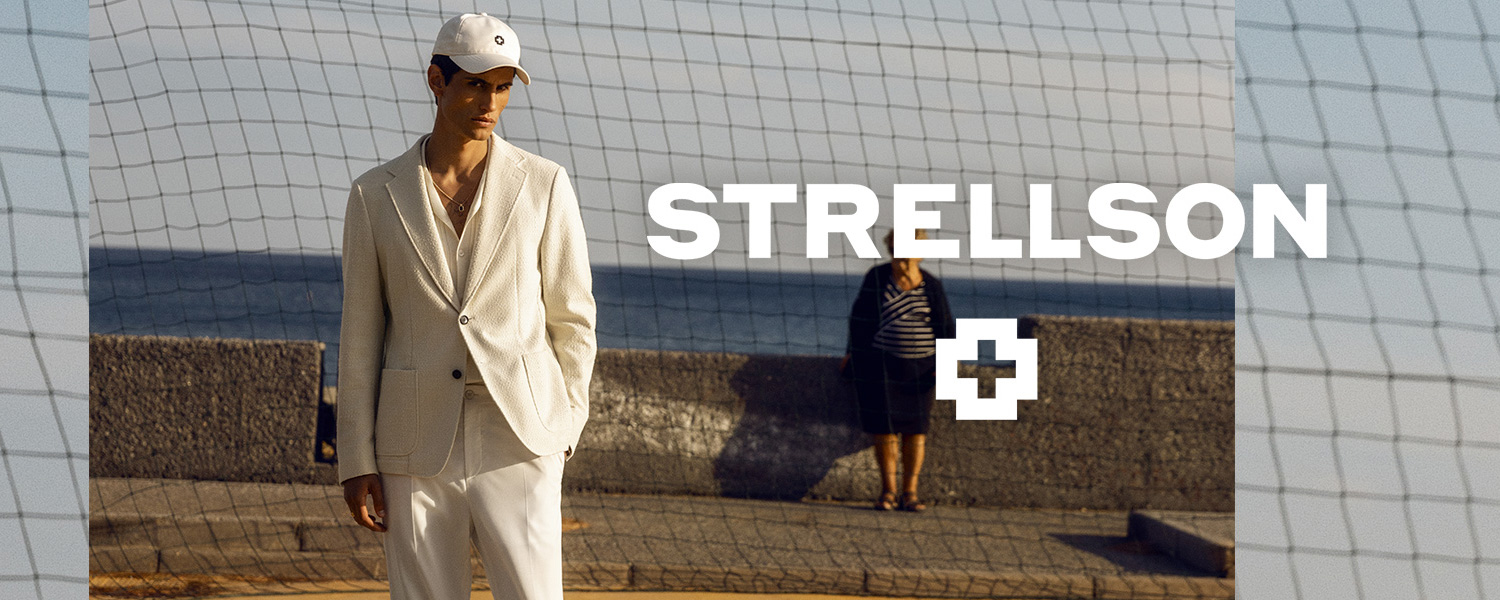 Mann in cremefarbenem Leinenanzug auf Sportplatz mit Strellson-Logo im Hintergrund