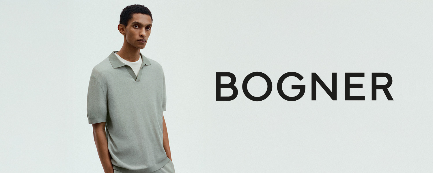 Ein Mann in mintgrünem Strick-Poloshirt blickt ruhig in die Ferne vor hellem Hintergrund – minimalistisches, modernes Ambiente.
