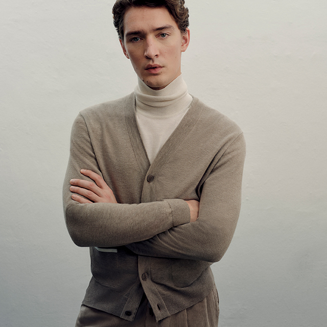 Ein Mann in einem beigen Cardigan von MAERZ Muenchen