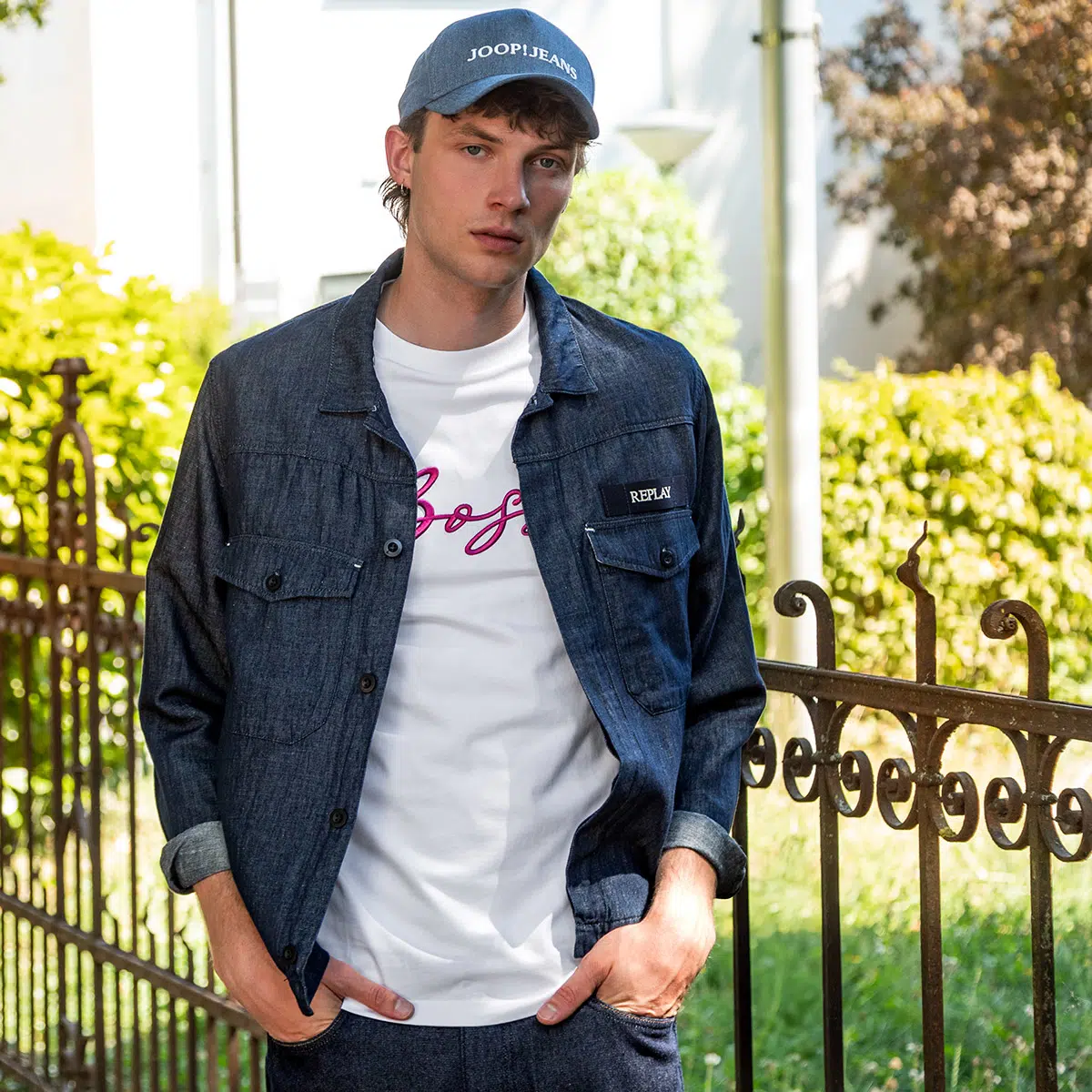 Ein junger Mann trägt eine Cap und ein Hemd aus Jeansstoff
