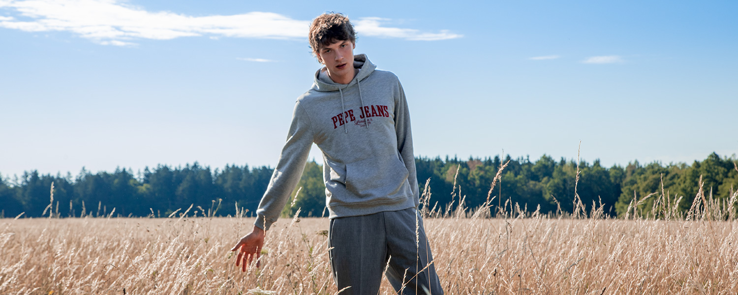 Ein junger Mann trägt einen monochromen Look in grau