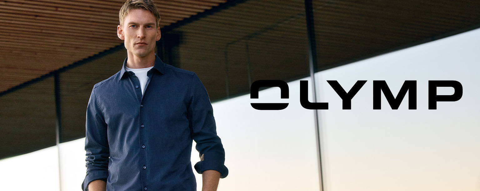 Mann in dunkelblauem Hemd von OLYMP steht selbstbewusst vor moderner Architektur – stilvolle Businessmode für Herren entdecken bei Herrenausstatter.de.
