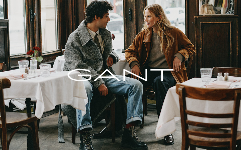 Ein Mann und eine Frau unterhalten sich in einem Restaurant. Mittiges Logo von Gant