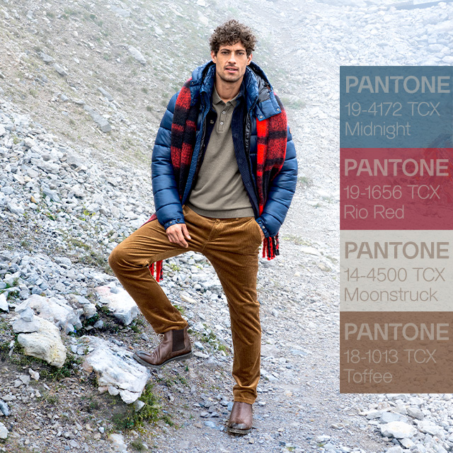 Mann in Outdoor-Outfit mit Daunenjacke, Cordhose und kariertem Schal in Pantone-Farben Midnight, Rio Red, Moonstruck und Toffee – herbstliche Herrenmode inspiriert von Naturtönen.