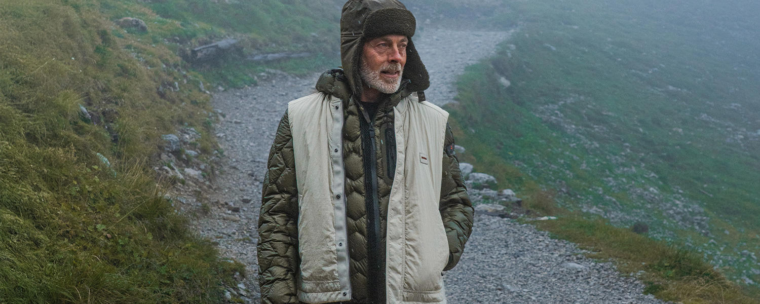Outdoor-Weste in Beige, kombiniert mit einer wattierten Jacke – funktionaler Layer-Look für herbstliche und winterliche Aktivitäten.