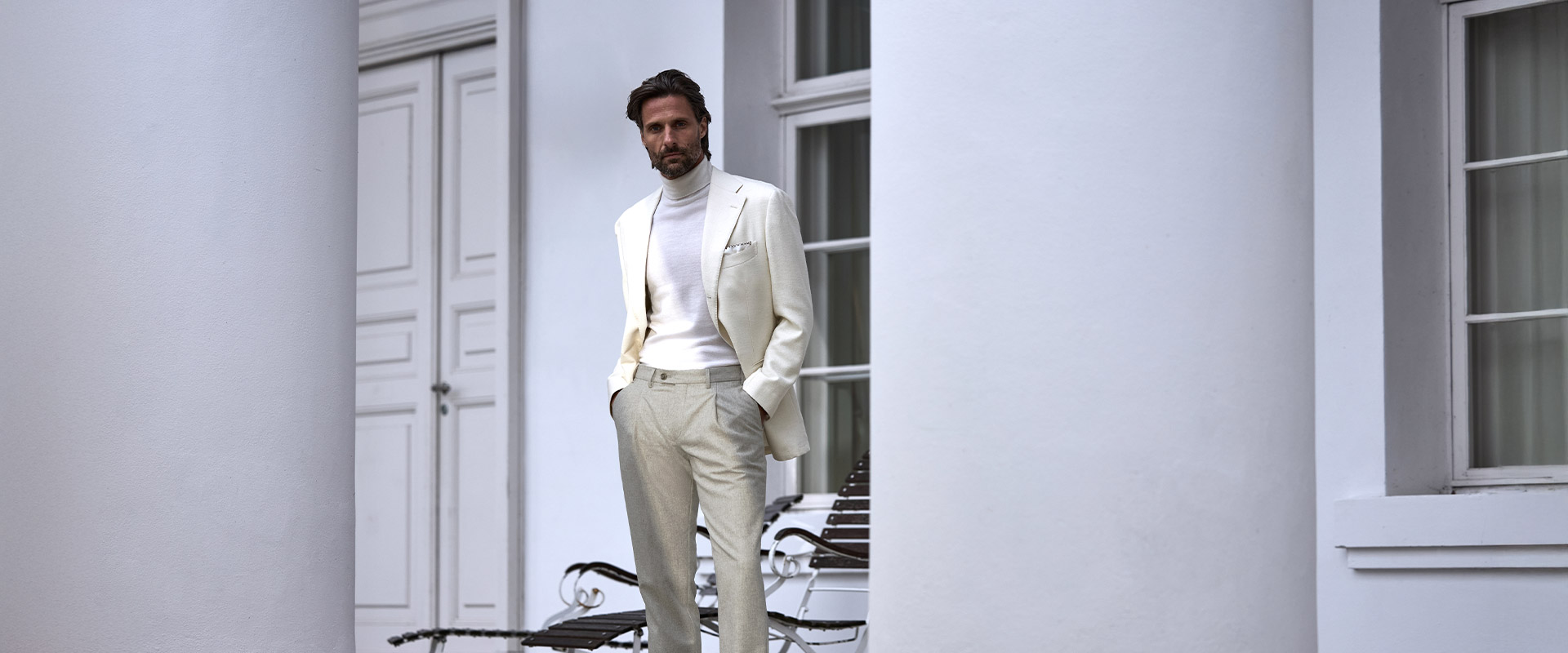 Weißer Rollkragenpullover mit hellem Anzug, cleanes Monochrom-Outfit im eleganten Look.