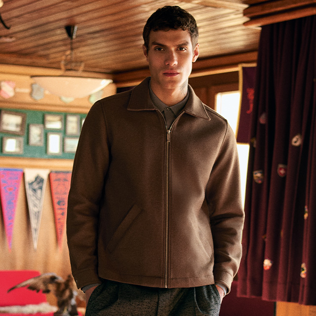 Braune Wolljacke mit Reißverschluss, kombiniert mit grauer Hose und Hemd, cleaner Casual-Look.
