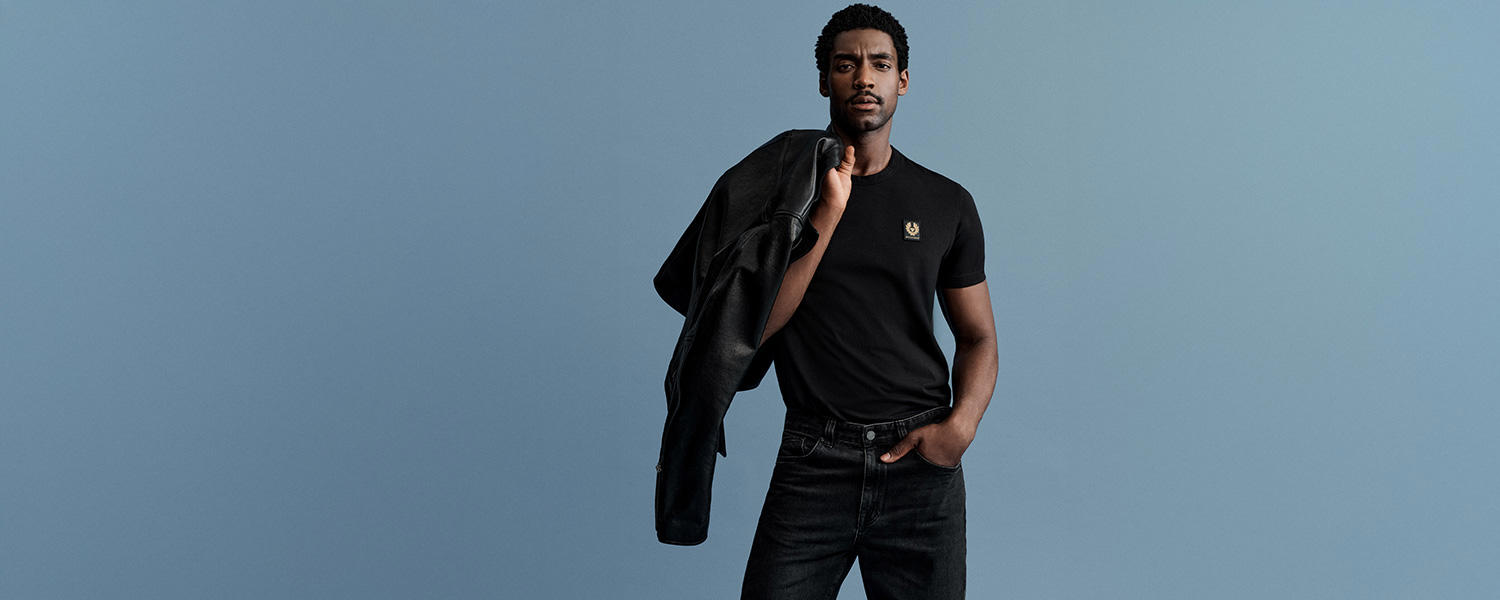 Schwarzes Belstaff T-Shirt mit Logo-Patch, kombiniert mit dunkler Jeans – cleaner Casual-Look mit lässiger Lederjacke.