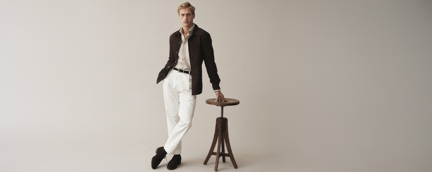 Stenströms Hemd in Beige, kombiniert mit weißer Hose und brauner Jacke – eleganter, skandinavisch inspirierter Smart-Casual-Look.
