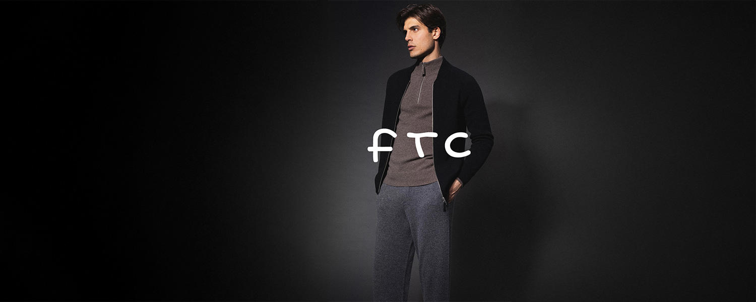 FTC Strickjacke in Schwarz über braunem Half-Zip-Pullover, kombiniert mit grauer Hose – moderner, gemütlicher Casual-Look.