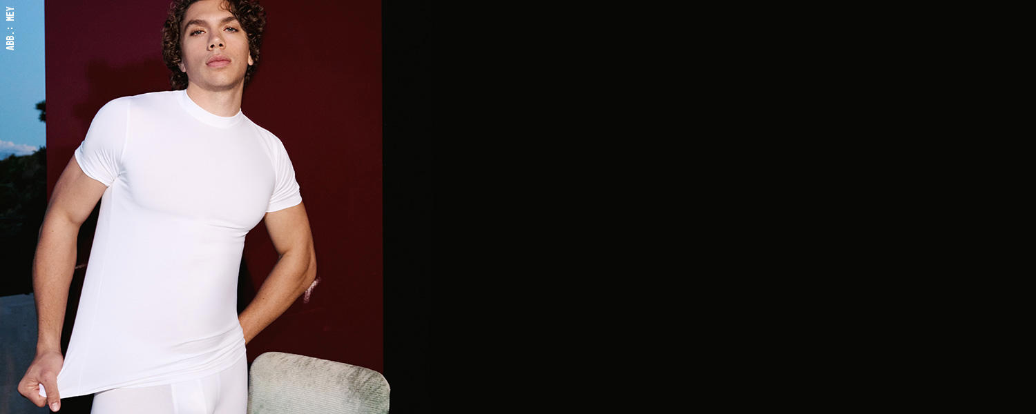 Mann in enganliegendem weißen T-Shirt, moderner Basic-Style für Alltag und Freizeit.