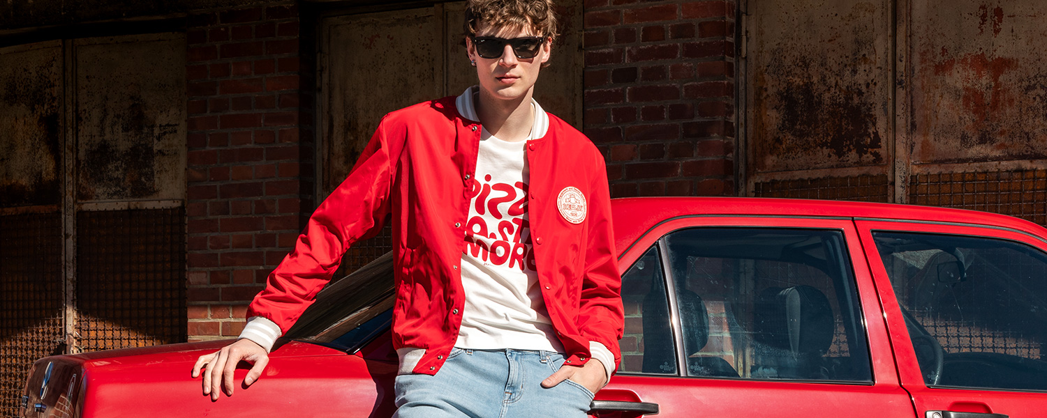Weißes Print-T-Shirt mit roter Jacke und Jeans – cooler Streetwear-Look mit Retro-Vibe.
