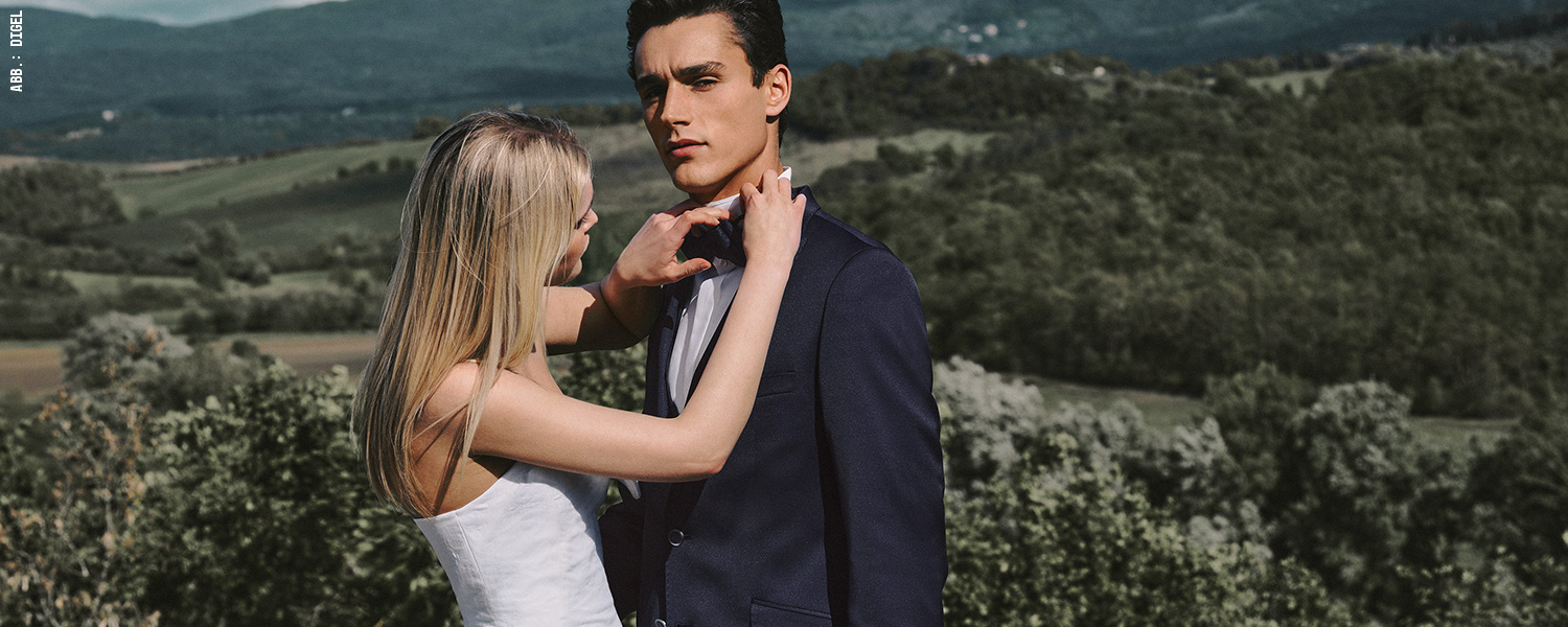 Dunkelblauer Smoking mit Fliege – eleganter Hochzeitsanzug für festliche Momente im Freien.