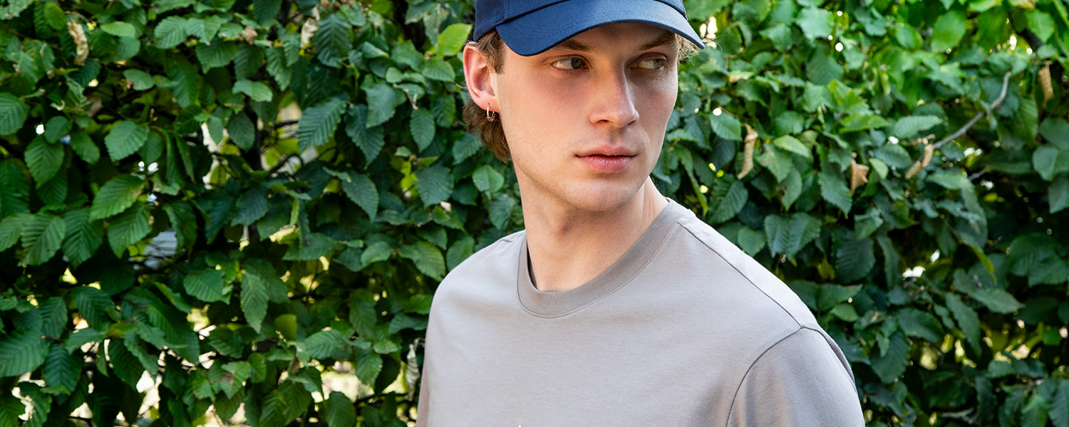 Beiges Rundhals-T-Shirt mit Navy-Cap – sportlich-urbaner Casual-Look im Alltag.