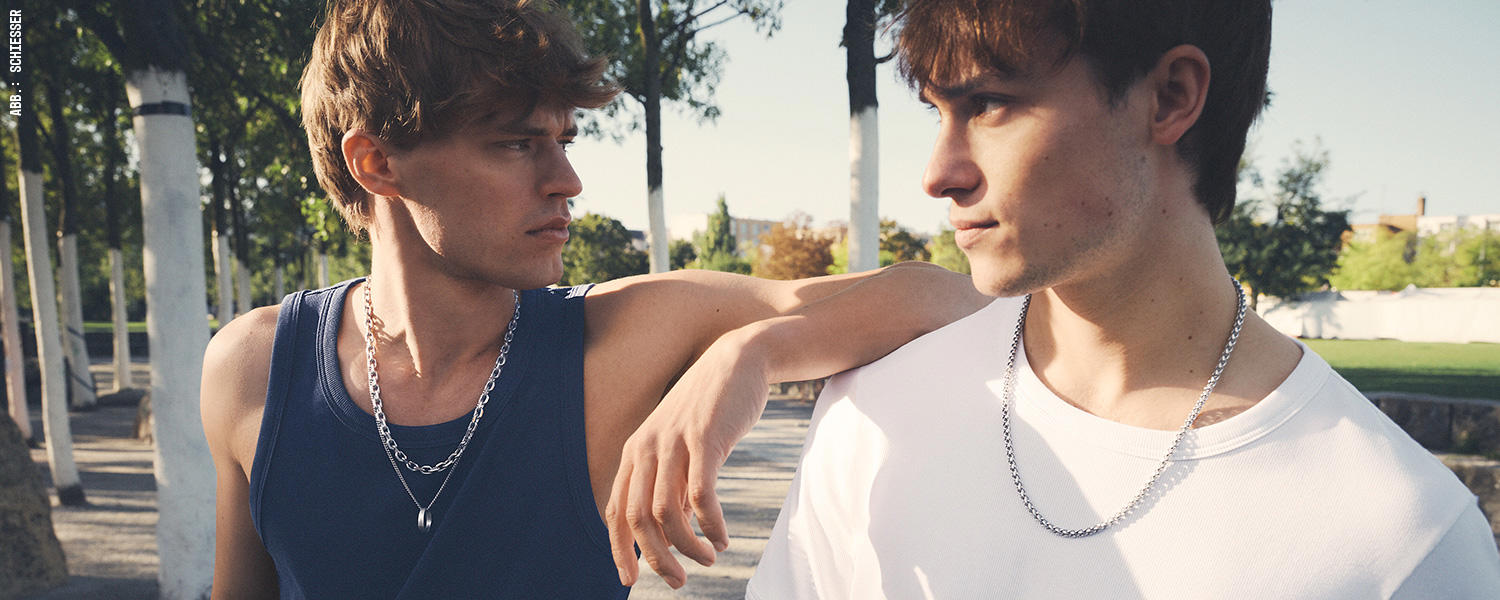 Dunkles Tanktop und weißes Shirt im Duo – sportlicher, moderner Look für warme Tage.
