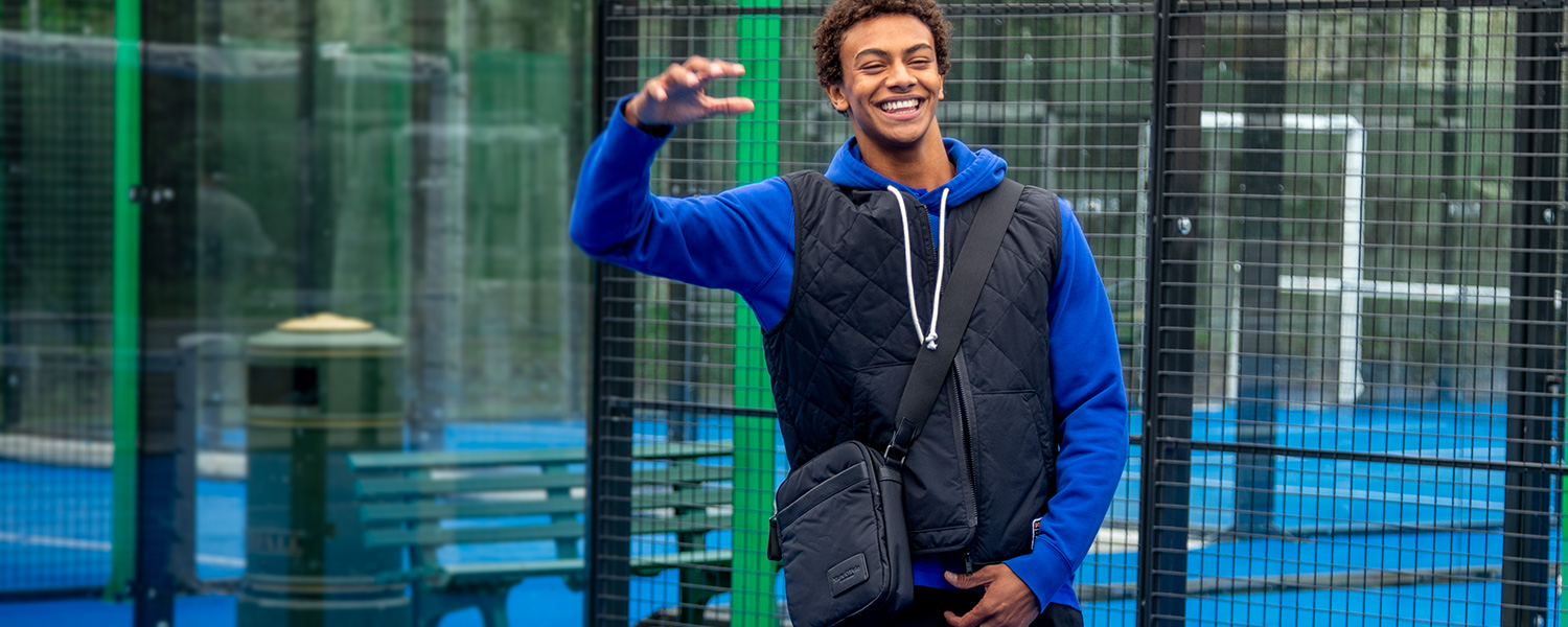 Mann in blauer Sweatjacke mit Kapuze und gesteppter Weste, sportlich-lässiger Freizeitstyle.