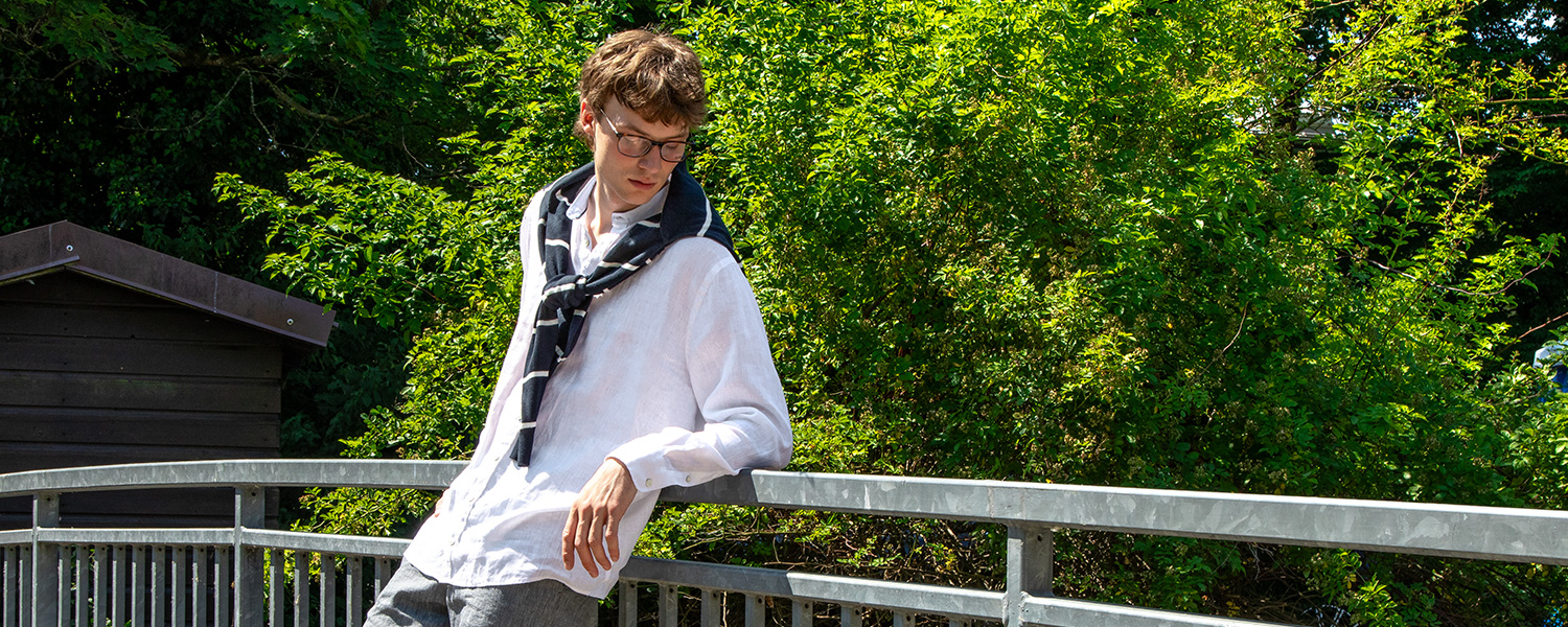 Weißes Leinenhemd mit gestreiftem Pullover – entspannter Freizeit-Look für warme Tage.