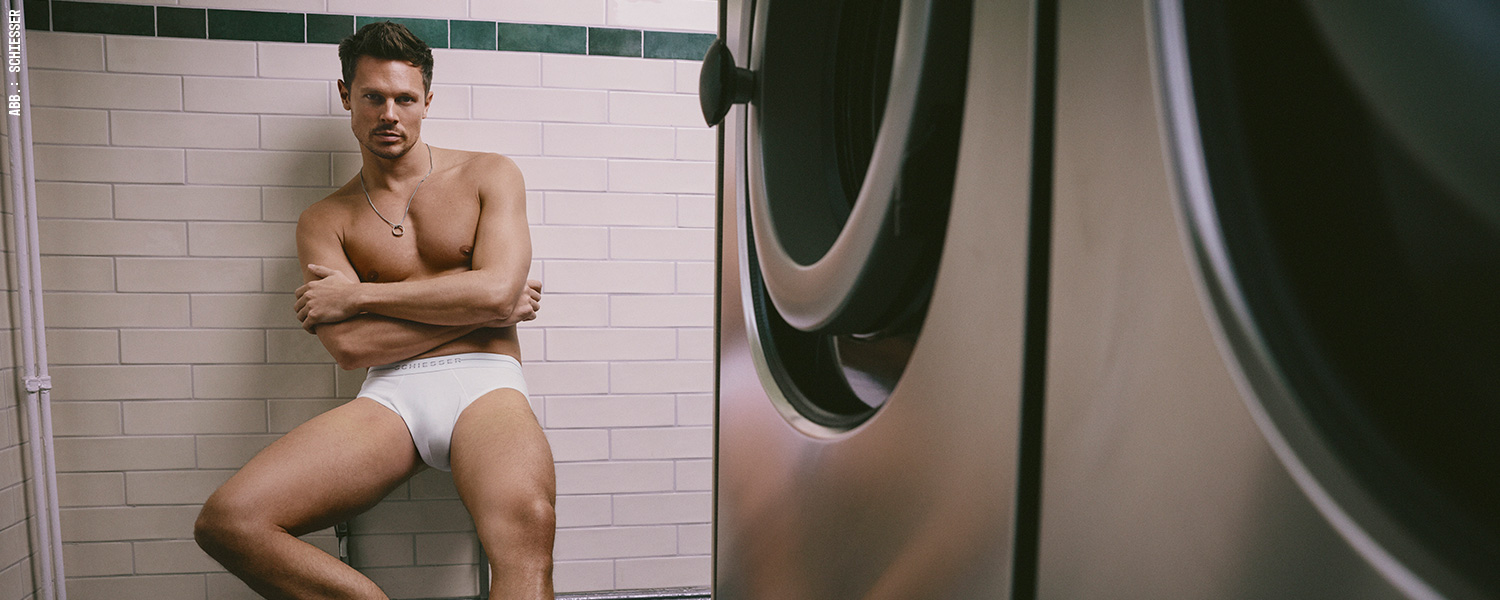 Mann in weißer Slip-Unterhose, cleaner Basic-Look in urbanem Umfeld.