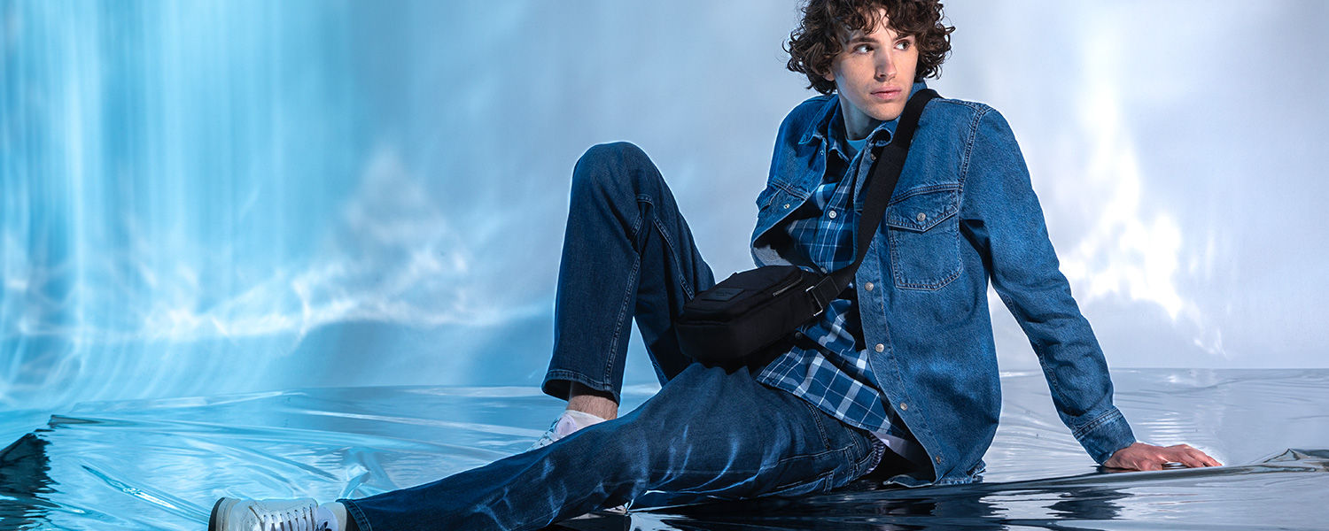 Jeansjacke im All-Denim-Stil – moderner Look mit schwarzer Crossbody-Tasche.