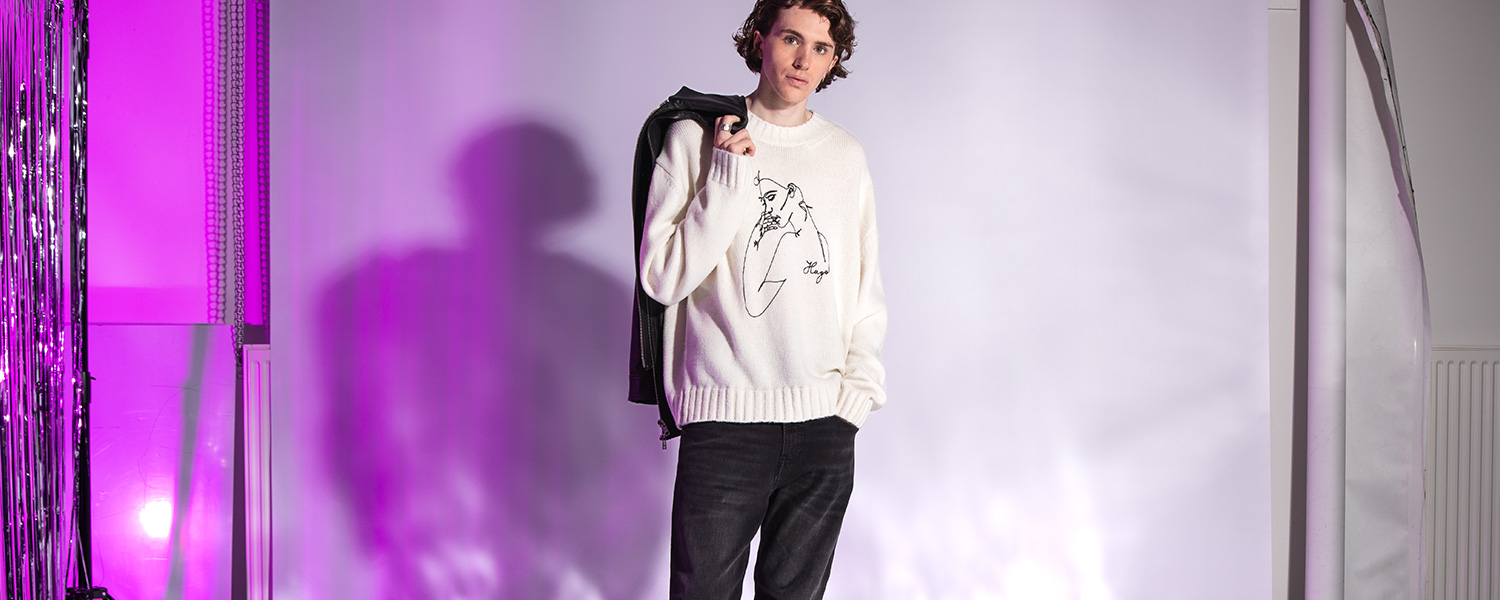 Jeans in dunkler Waschung – eleganter Look mit weißem Pullover und Lederelementen.