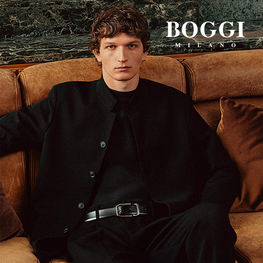 Schwarze Jacke aus Baumwolle, legerer Look auf braunem Ledersofa sitzend