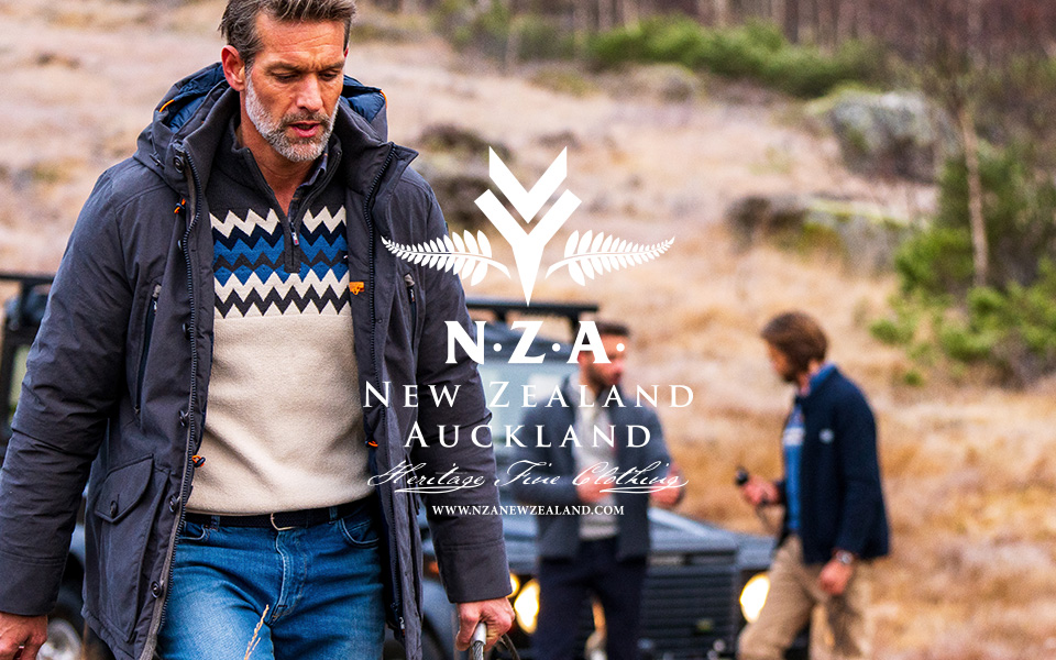 Dunkelblaue Jacke über cremefarbenem Pullover mit Zickzack-Muster, leger im Freien getragen