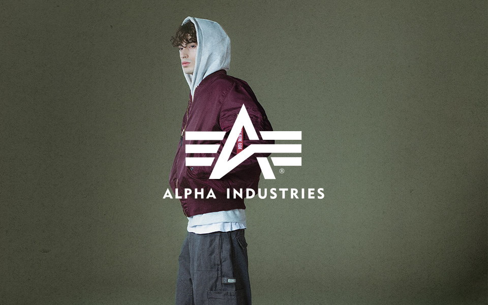 Junger Mann in bordeaux Bomberjacke und grauem Hoodie, lässig kombiniert