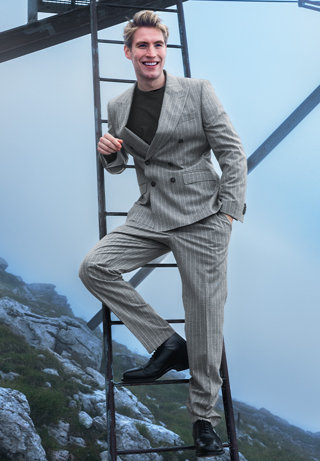Grau gestreifter Anzug aus Wolle, leger mit dunklem Shirt kombiniert, draußen präsentiert