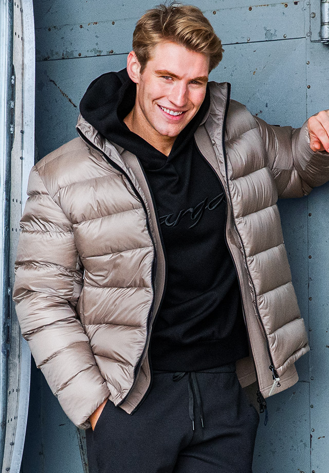 Beige Daunenjacke über schwarzem Hoodie, leger getragen im Freizeitlook