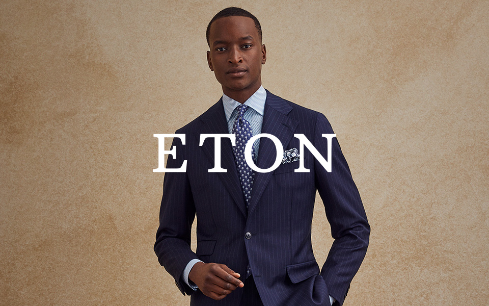 Mann im dunkelblauen Nadelstreifen-Anzug mit gemusterter Krawatte und Einstecktuch