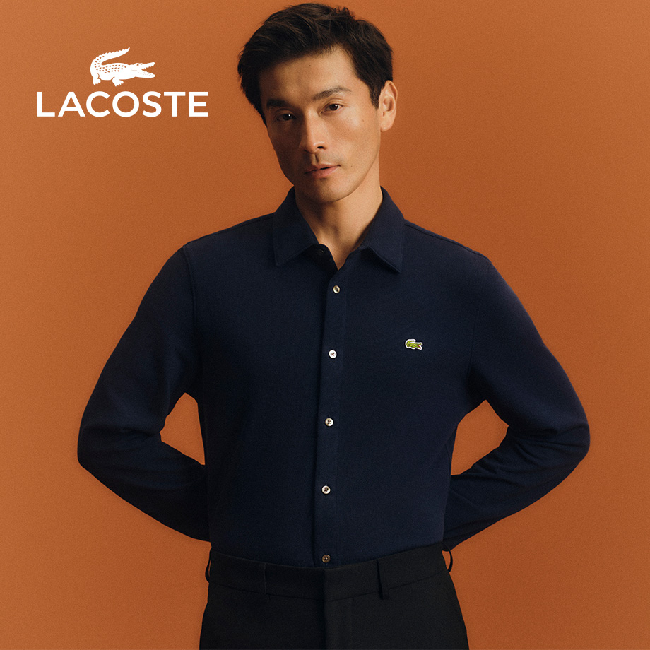 Mann in dunkelblauem Langarm-Poloshirt aus Baumwolle vor orangefarbenem Hintergrund