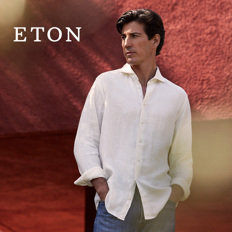 Mann in weißem Leinenhemd mit langen Ärmeln und Jeans im Freien