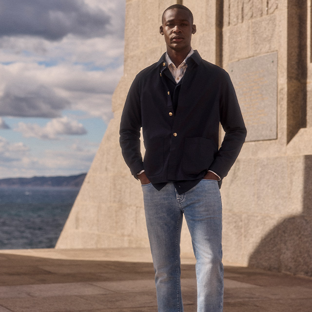 Elegante marineblaue Jacke über Hemd, kombiniert mit hellblauen Jeans, lässig getragen